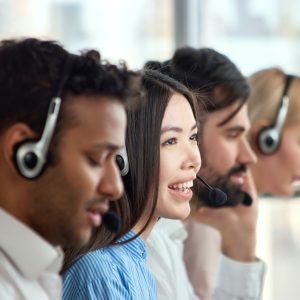 Four support phone operators at workplace.